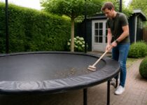 Trampoline in de tuin wordt schoongemaakt met een zachte borstel