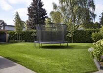 Trampoline met veiligheidsnet in een ruime achtertuin