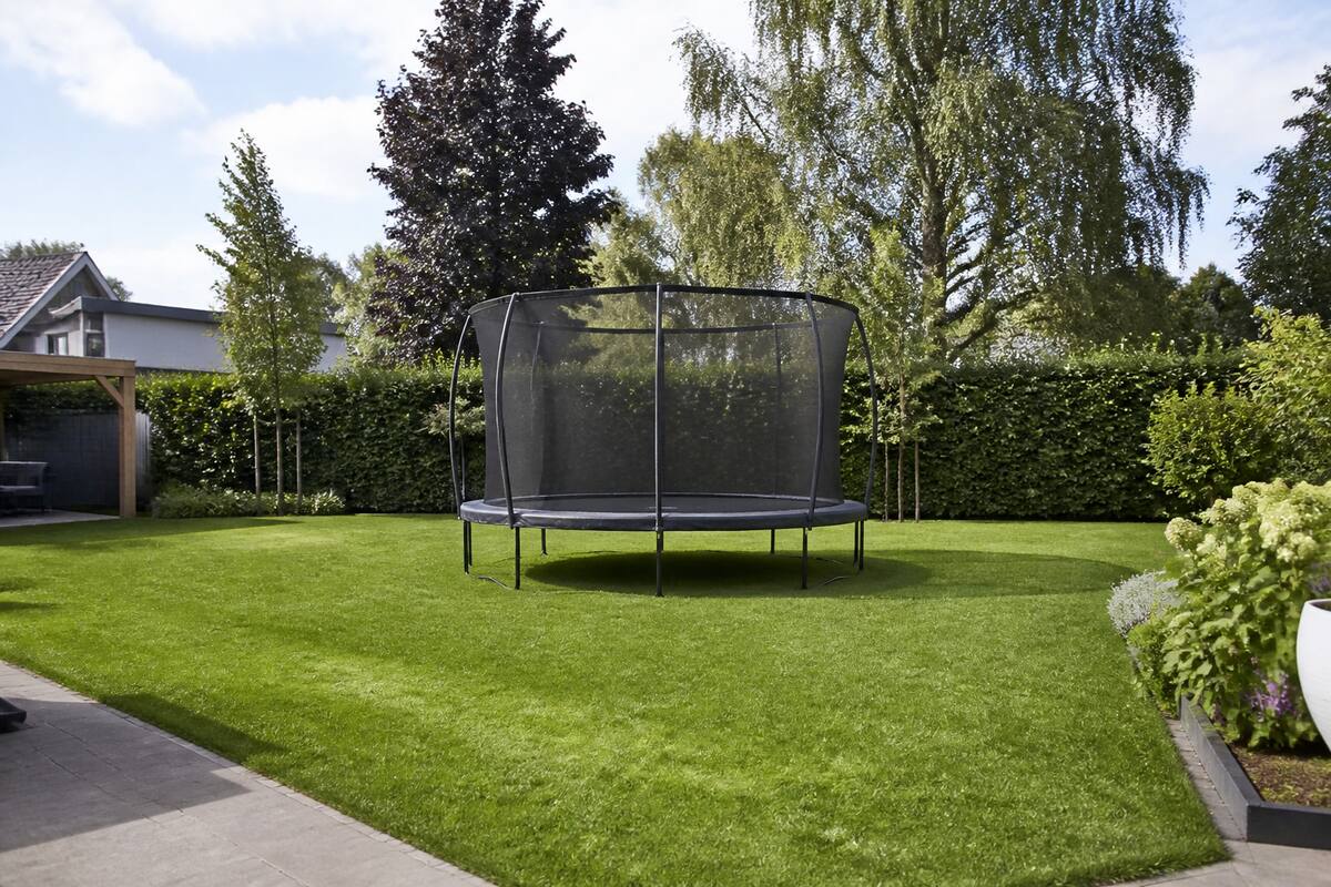 Trampoline met veiligheidsnet in een ruime achtertuin