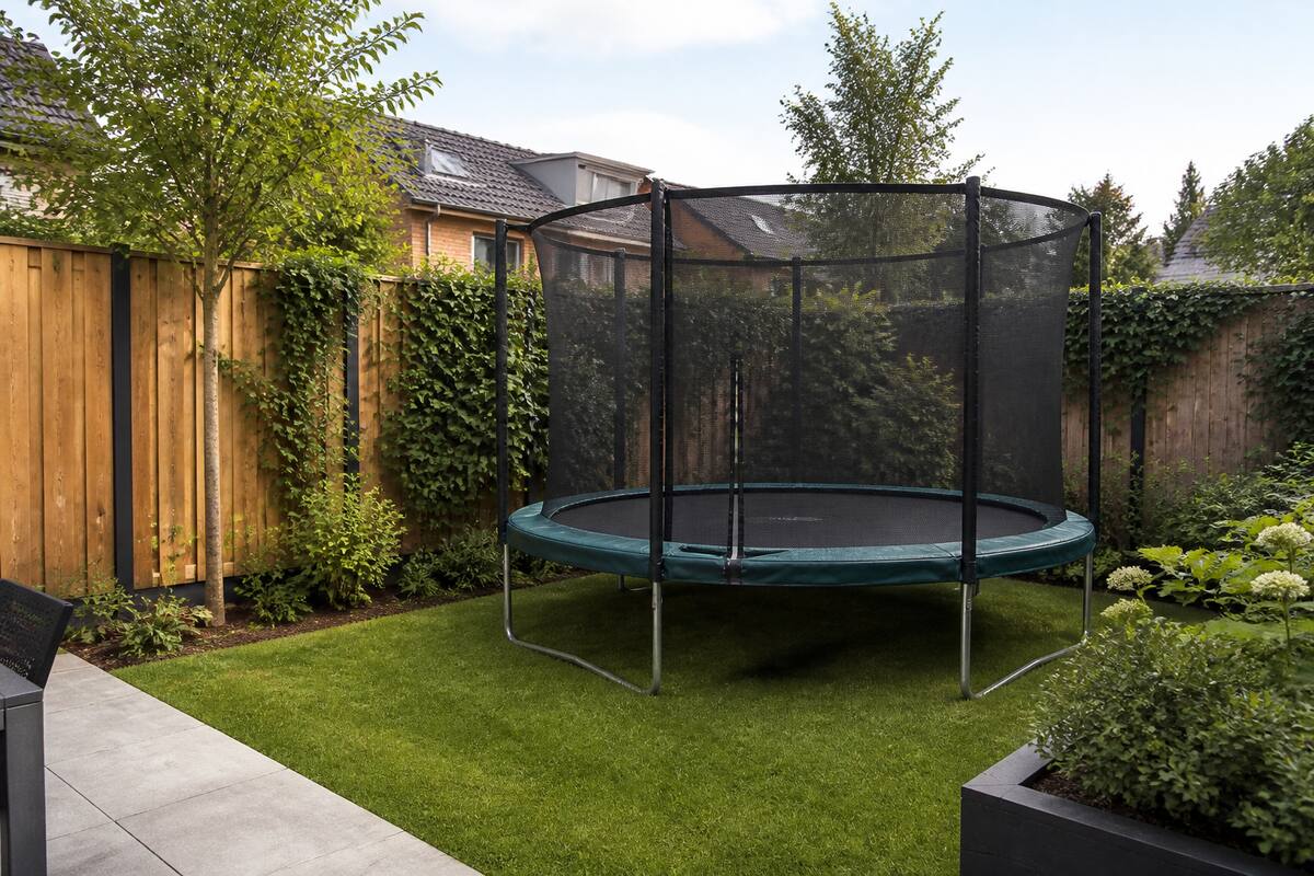 Middelgrote trampoline met veiligheidsnet in een ruime achtertuin