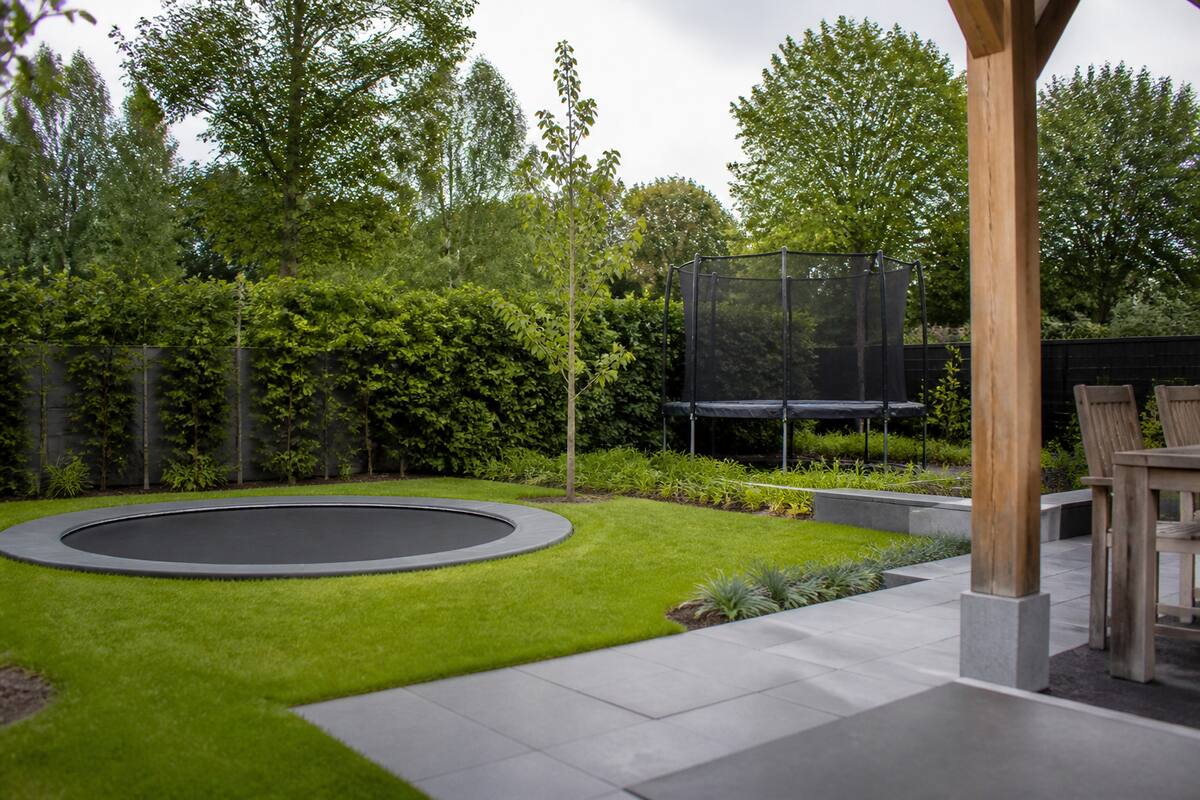 Inground en opbouw trampoline in een achtertuin ter vergelijking