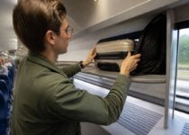 Reiziger die compacte bagage overzichtelijk plaatst in de trein