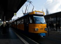 A yellow and blue tram at a station